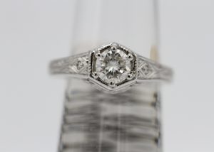 A large silver ring with a large diamond centerpiece