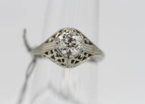 A large silver ring with a very large diamond centerpiece