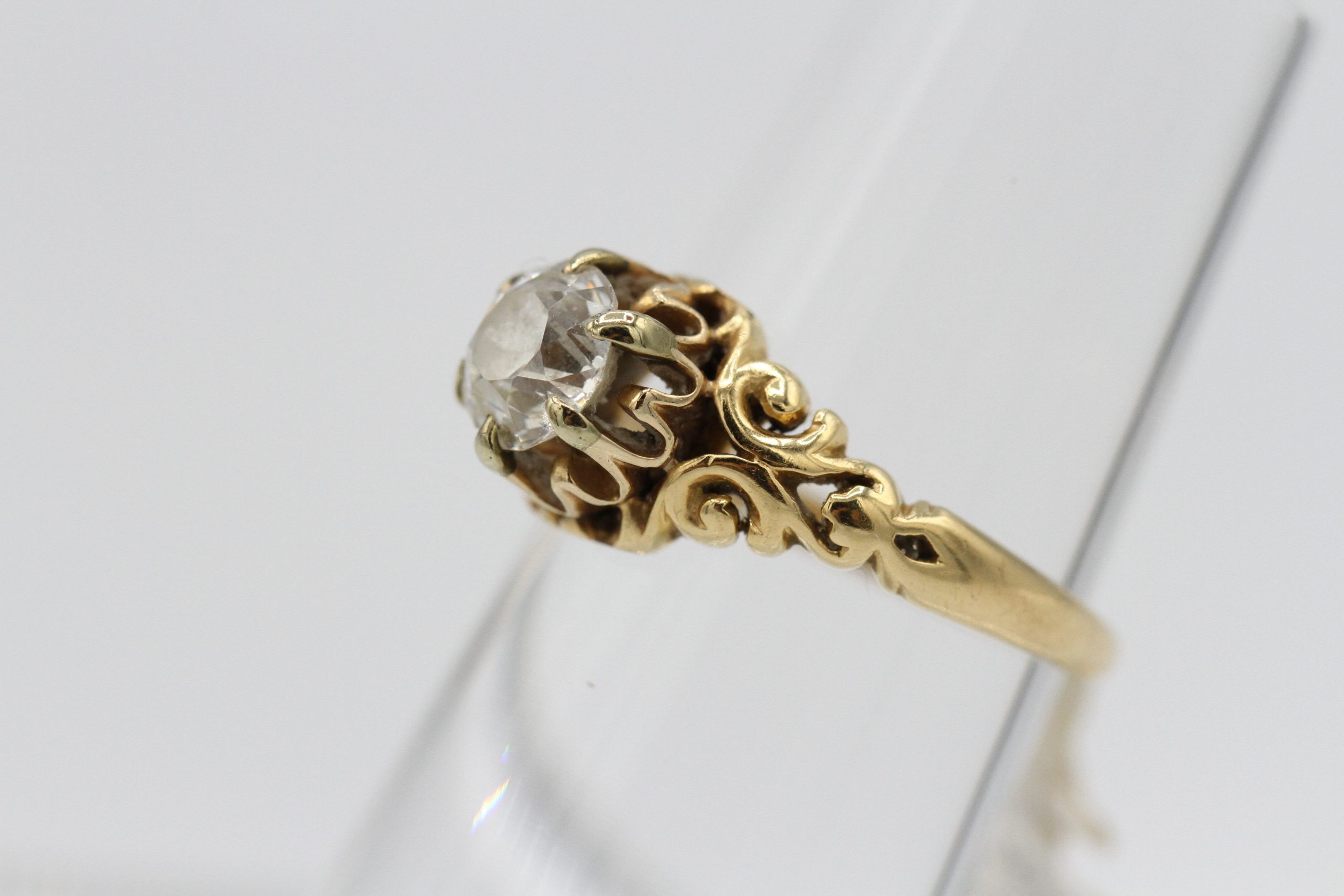 An ornate gold ring with a large diamond centerpiece