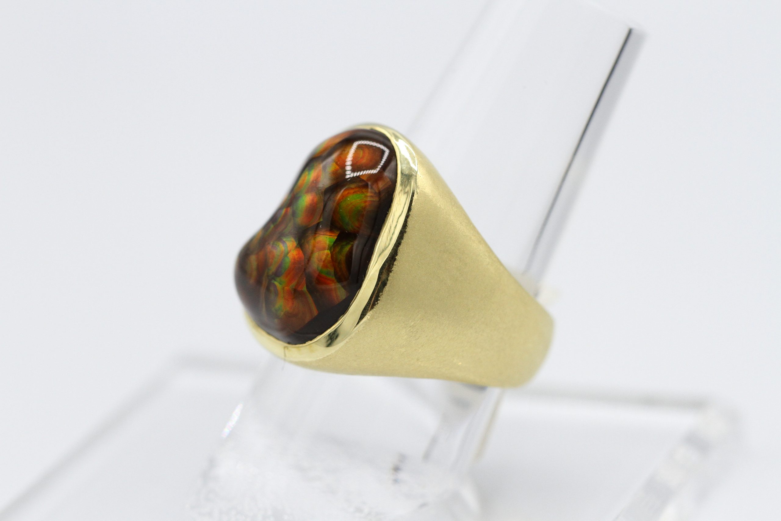 A gold ring with a large, dark gemstone