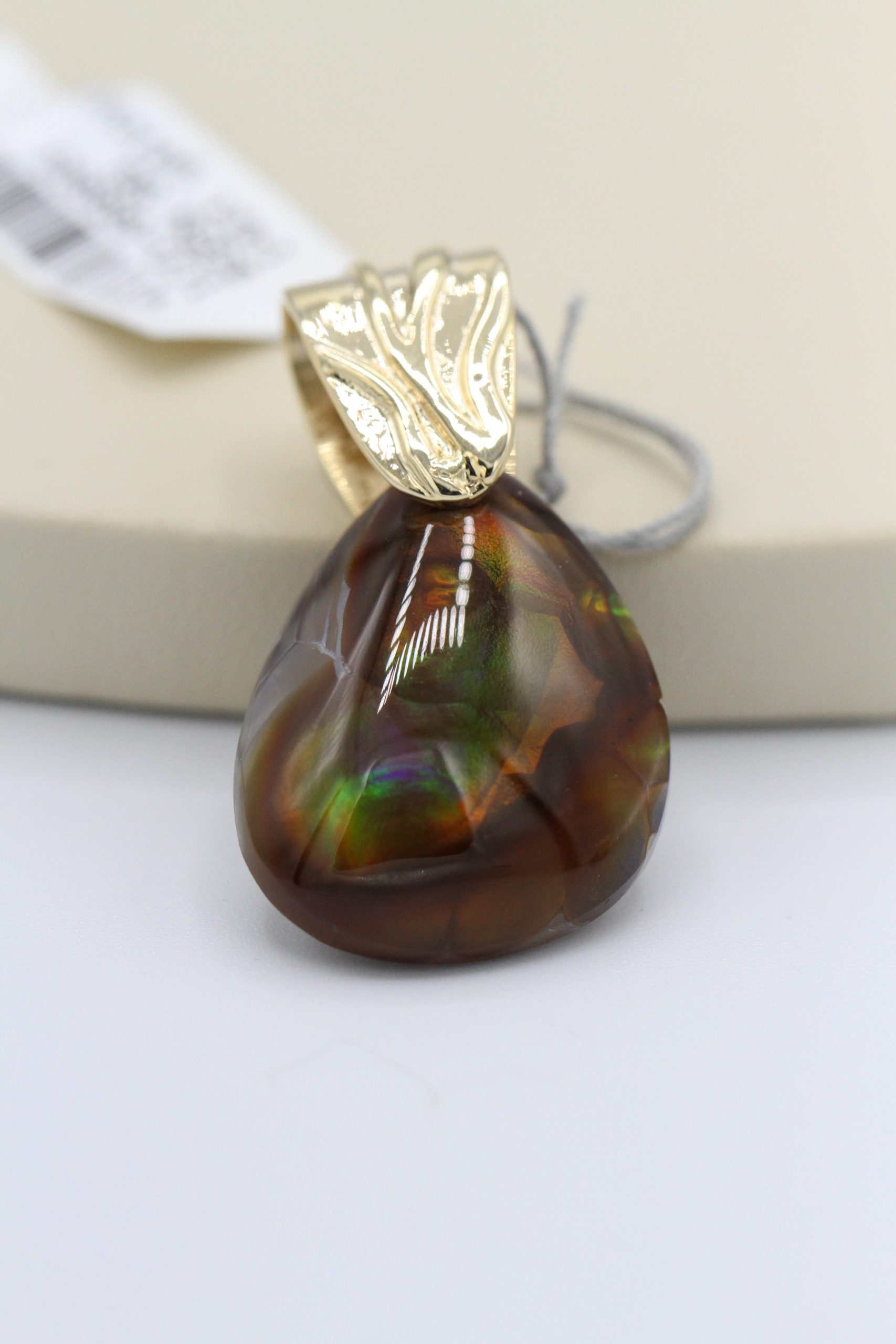 A gold earring with a large, dark gemstone