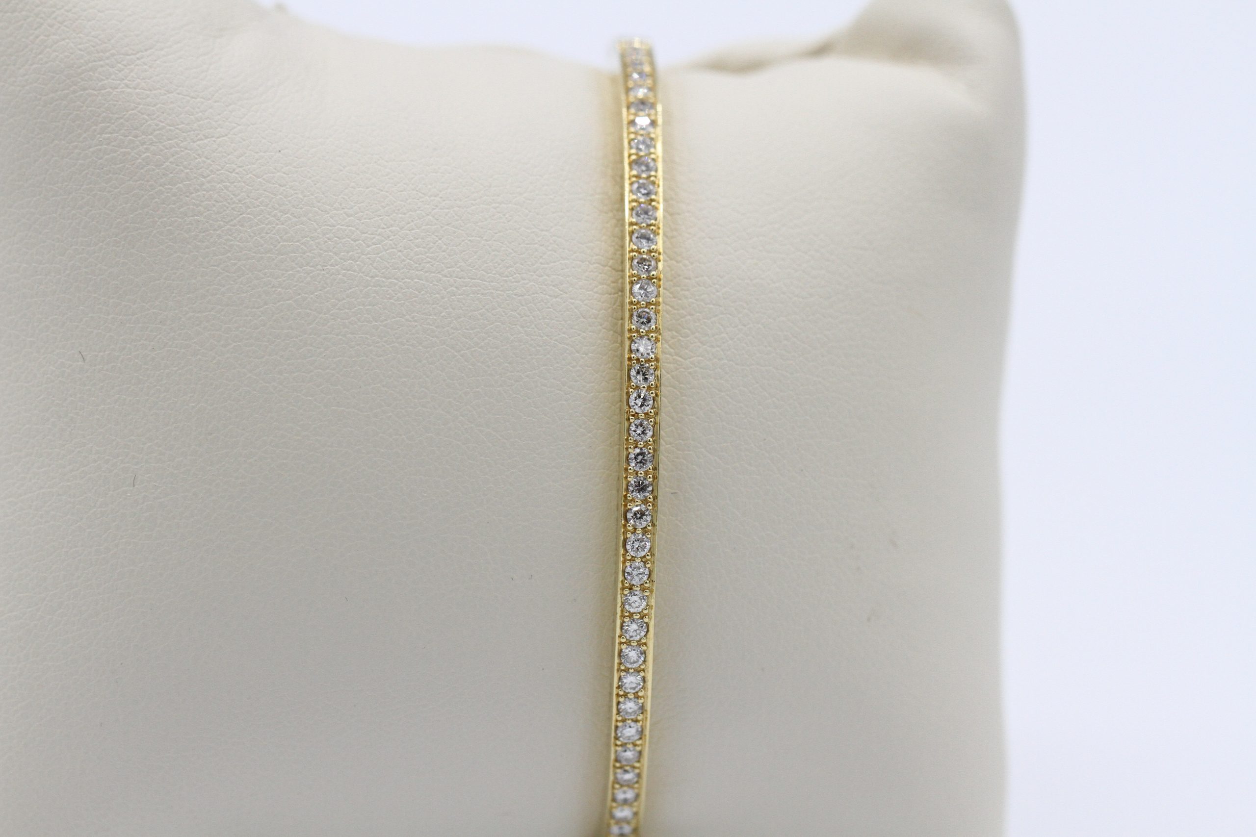 A small, gold bracelet with diamond encircling it.