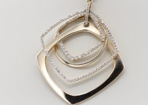 A necklace with a gold, square centerpiece inlaid with diamonds.