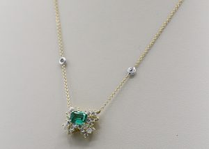An ornate gold, emerald, and diamond necklace