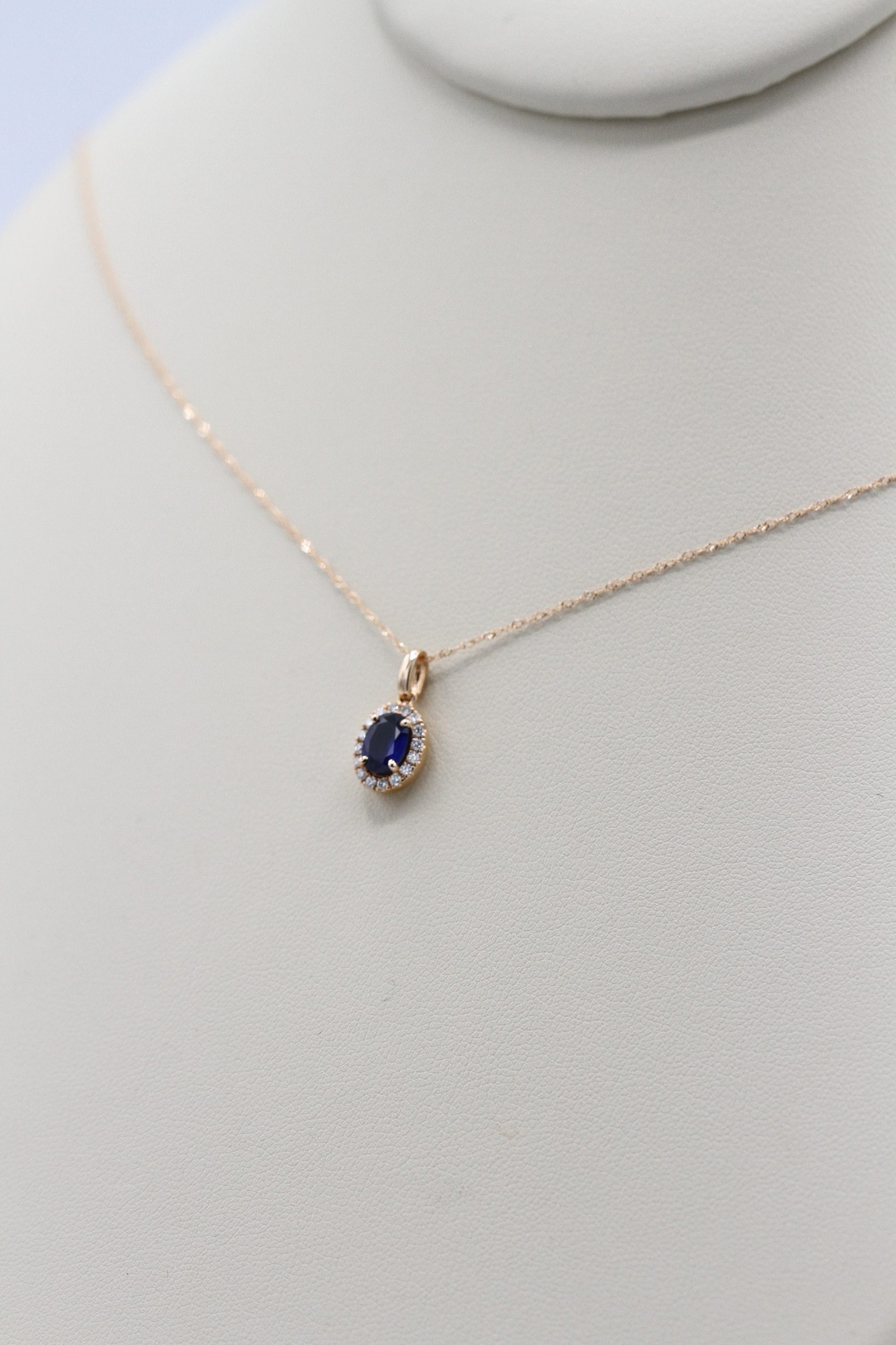 A necklace with a small blue stone and surrounding diamonds