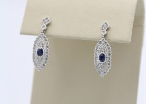 White, ornate earrings with large, blue stones