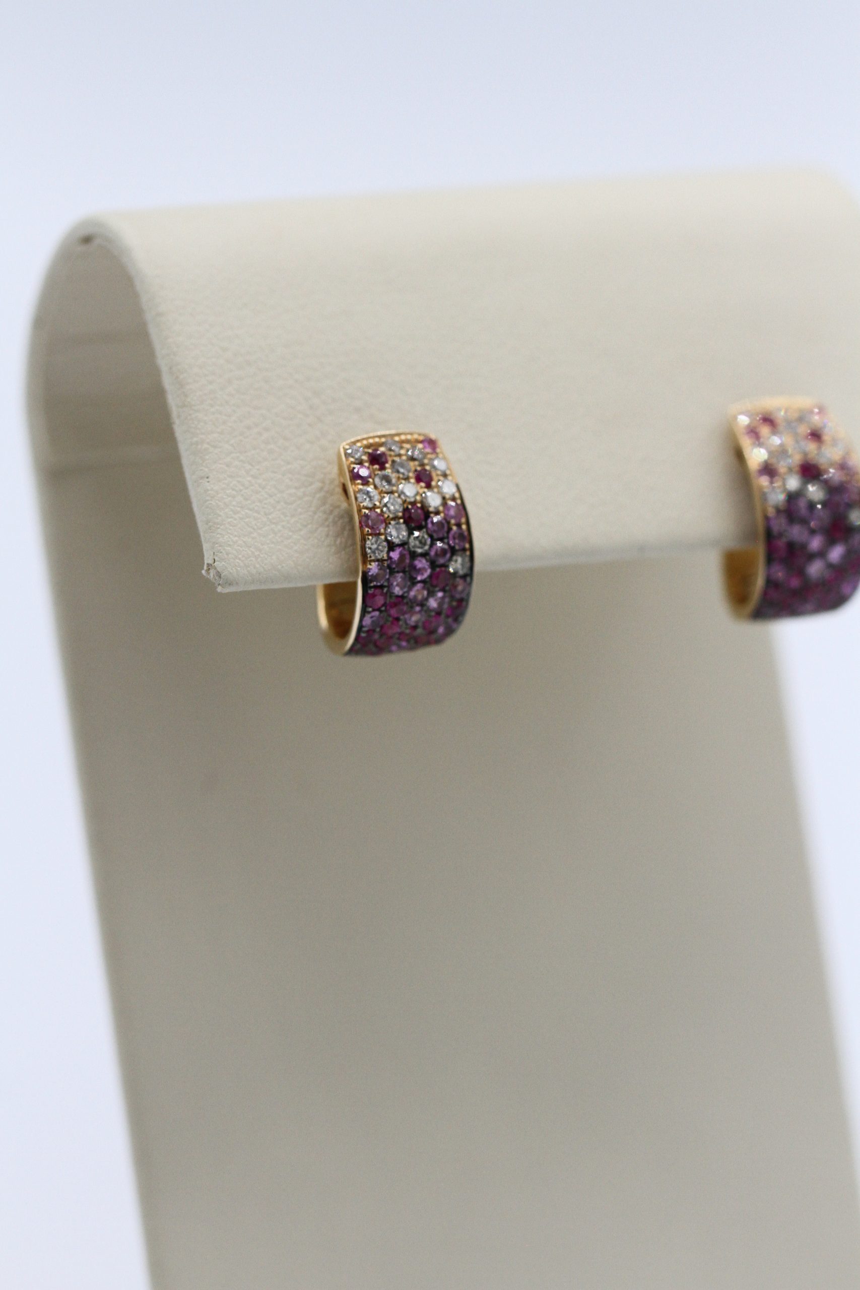 Two earrings with purple and white stones