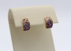 Two earrings with purple and white stones